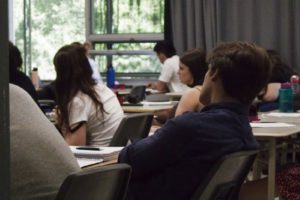 A group of people sitting at a table with laptops